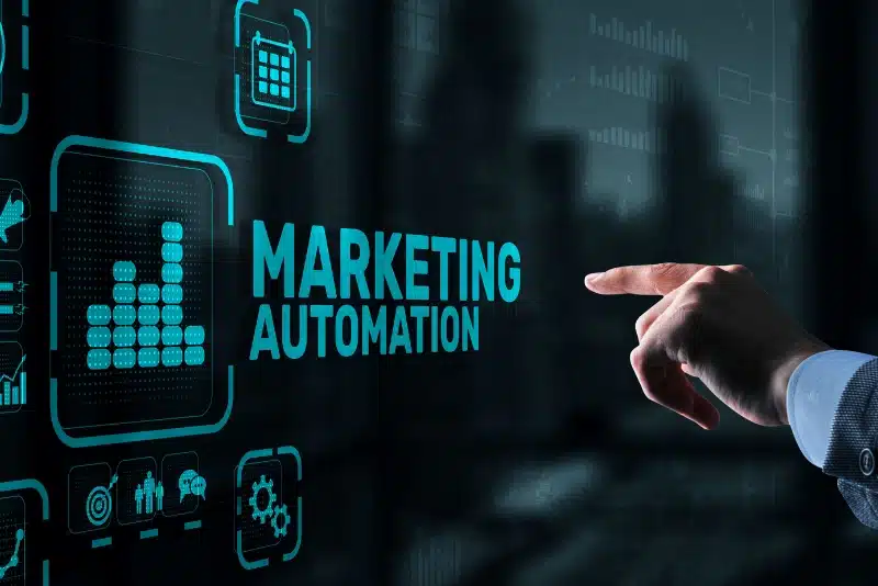 Person pointing at a digital screen displaying the words "Marketing Automation" alongside futuristic data and analytics icons.