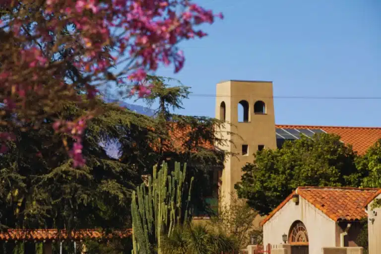 Aerial view of El Monte, California with highway intersections, office buildings, and San Gabriel Mountains in the background.